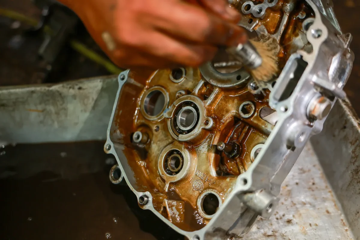 Brush cleaning residue from a metal engine component during maintenance