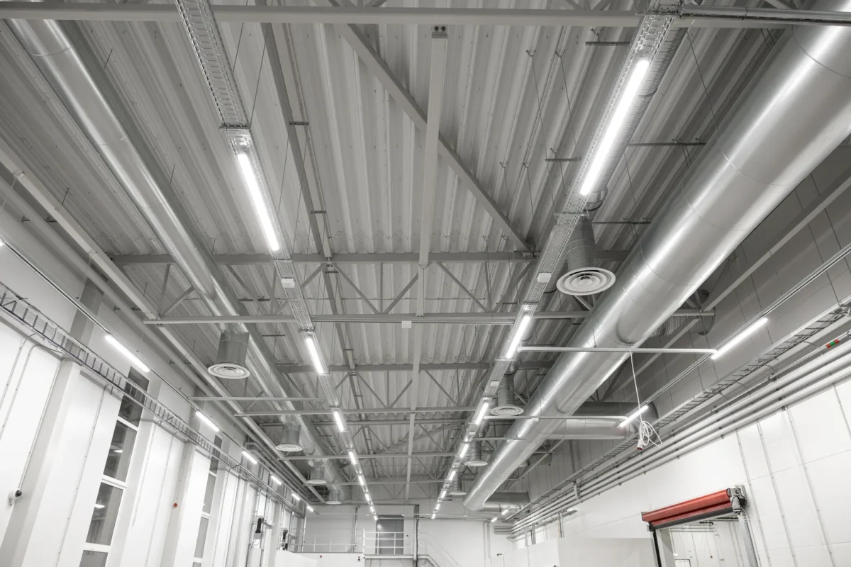 Roof beams, lights and ventilation ducts above a high industrial workspace