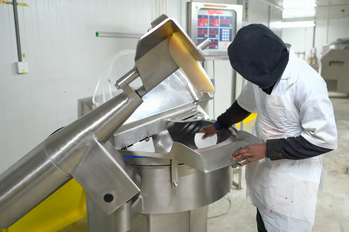 Worker cleaning the inside of a food processing machine